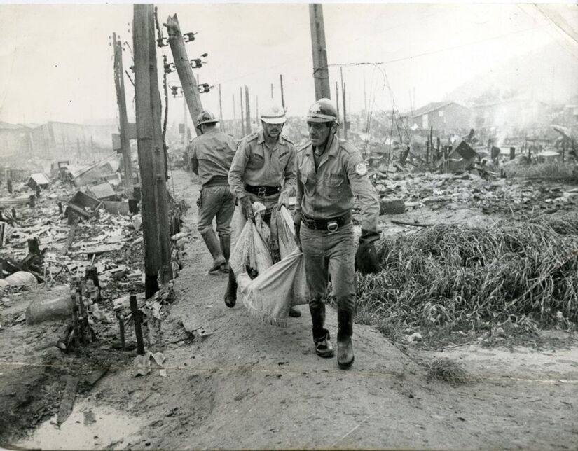 Soldados do Corpo de Bombeiro, retiram corpos de destroços após incêndio na Vila Soco, em Cubatão (SP). (Foto: Ademir Barbosa/Folhapress/25/02/1984)