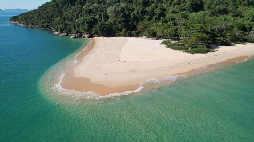 Na ponta direita da praia de Prumirim, caiçaras se encarregam de fazer o transporte dos banhistas