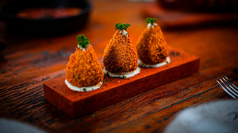 Entre os destaques do cardápio está a lendária coxinha de cupim, receita secreta criada por Netão e assada por 24 hora - Reprodução/Mitsua Hirata