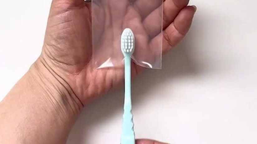 Insira o cabo da escova de dentes no entalhe e feche o zíper. Créditos: reprodução 