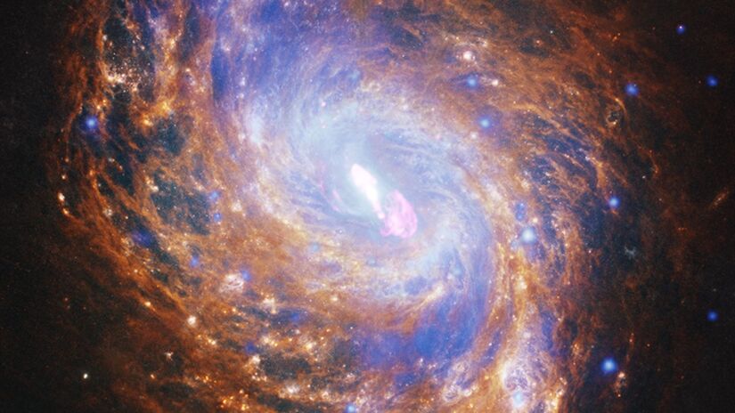 NGC 1068 é uma galáxia espiral relativamente próxima que contém um buraco negro em seu centro, duas vezes mais massivo que o da Via Láctea / Raio X: NASA/CXC/SAO; Óptico/IR: NASA/ESA/CSA/STScI (HST e JWST); Rádio: NSF/NRAO/VLA; Processamento de imagem: NASA/CXC/SAO/J. Schmidt e N. Wolk
