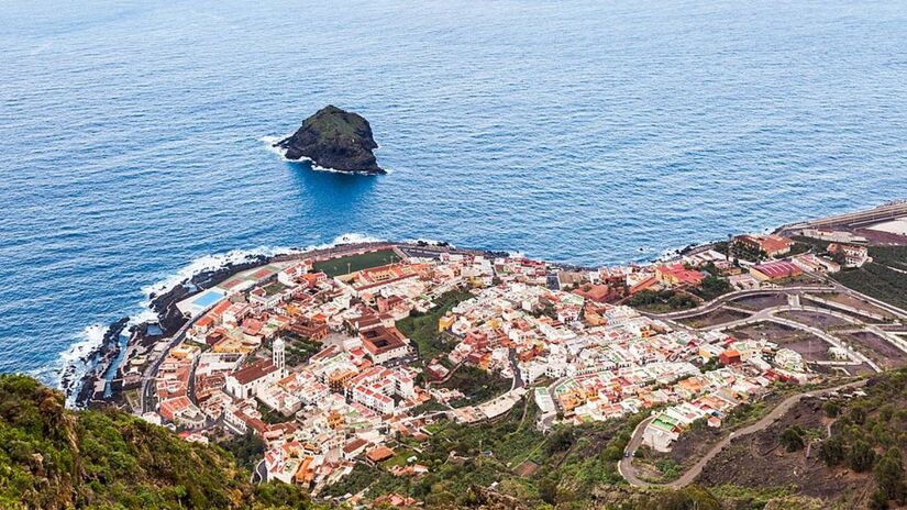 Garachico, Tenerife: Vista aérea de Garachico, um dos vilarejos mais charmosos do norte de Tenerife. A cidade foi parcialmente destruída por uma erupção vulcânica em 1706, mas ressurgiu preservando sua arquitetura colonial e um porto pitoresco cercado por piscinas naturais formadas pela lava/ Diego Delso/Wikimedia Commons