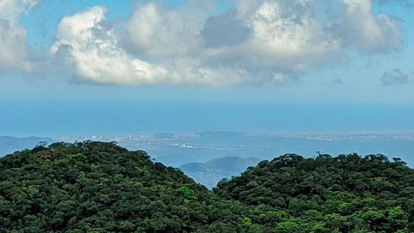 Parte do bairro está inserida na Serra do Mar, com altitudes que podem passar dos 1.000 metros. Essa posição alta, somada à proximidade com o litoral, cria uma perspectiva direta sobre a planície costeira. Google Maps / Ricardo Rocha / Reprodução