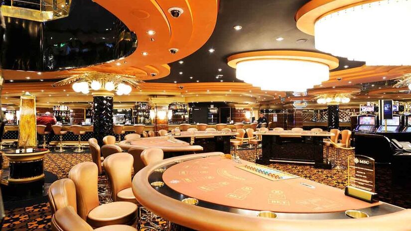 Cassino luxuoso e elegante com mesas de jogos e máquinas caça-níqueis para quem gosta de emoção e entretenimento/ PromoAção