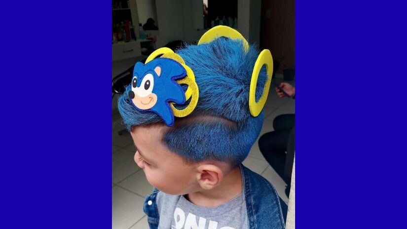 Com tinta azul e detalhes em EVA, o penteado recria o herói veloz dos videogames com direito a argolas douradas/ Reprodução Instagram/@geehh__saantoos