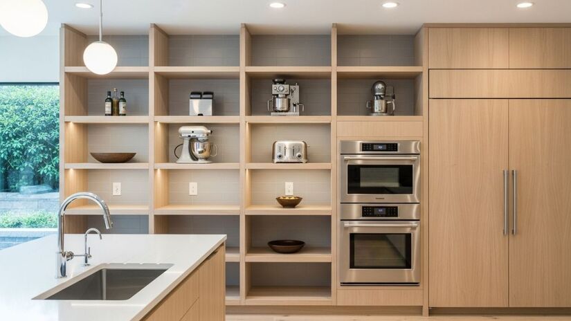 Esses móveis aproveitam a altura das paredes, liberando espaço nas bancadas e contribuindo para uma sensação de leveza e sofisticação na cozinha