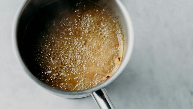 Depois de cozinhar: Vinagre e água fervente

Ferva uma mistura de duas partes de água para uma de vinagre branco e deixe na cozinha logo após a fritura. O ácido acético neutraliza as partículas de gordura, eliminando o odor em poucos minutos.

Embora o vinagre tenha um cheiro inicial forte, ele desaparece rapidamente, levando o mau cheiro junto/Pexels