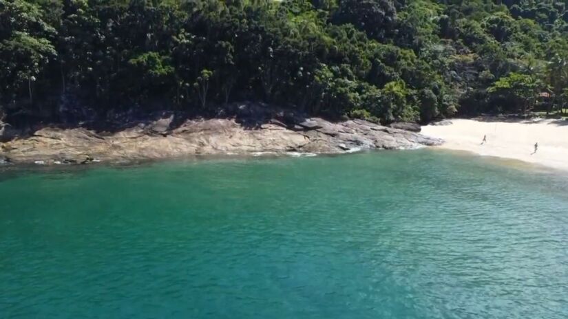 No canto esquerdo da praia, existe um rio de água doce raso, ideal para quem procura relaxar sem precisar entrar no mar (Vida de Praieiro/Youtube/Reprodução)