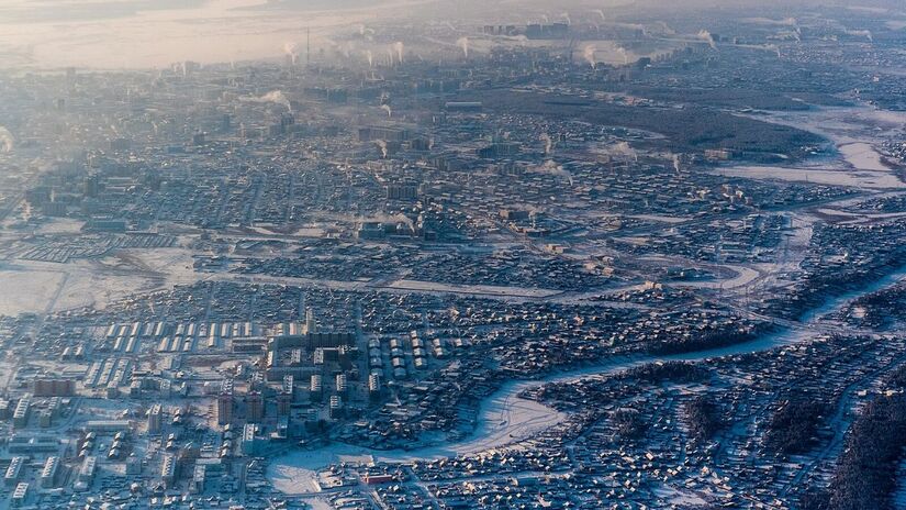 A cidade mais fria do mundo vista do alto: Yakutsk aparece coberta de neve e fumaça das calefações, evidenciando o impacto do inverno extremo na rotina urbana/ Ilya Varlamov/Wikimedia Commons