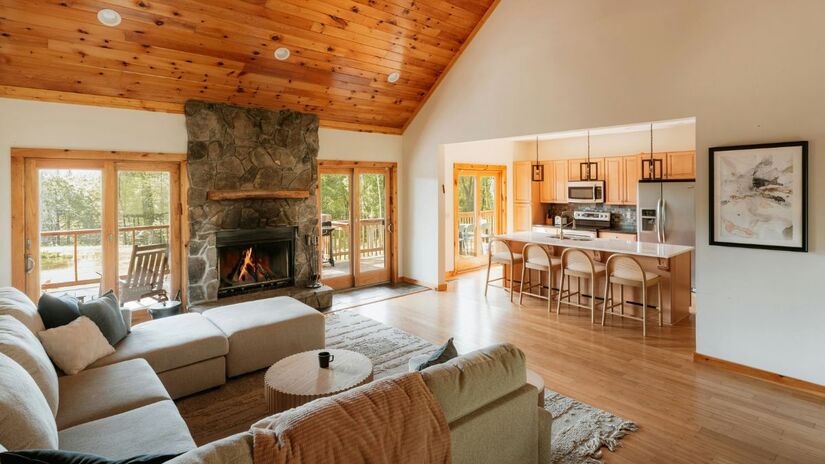 O conceito aberto integra sala de estar, cozinha e áreas externas, criando um espaço contínuo onde a iluminação natural e os materiais rústicos reforçam a sensação de amplitude e acolhimento/ Clay Banks/Unsplash