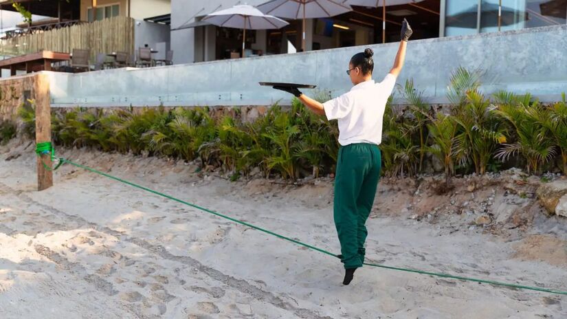 Atividades como slackline complementam a proposta de bem-estar e descontração na areia/ Divulgação