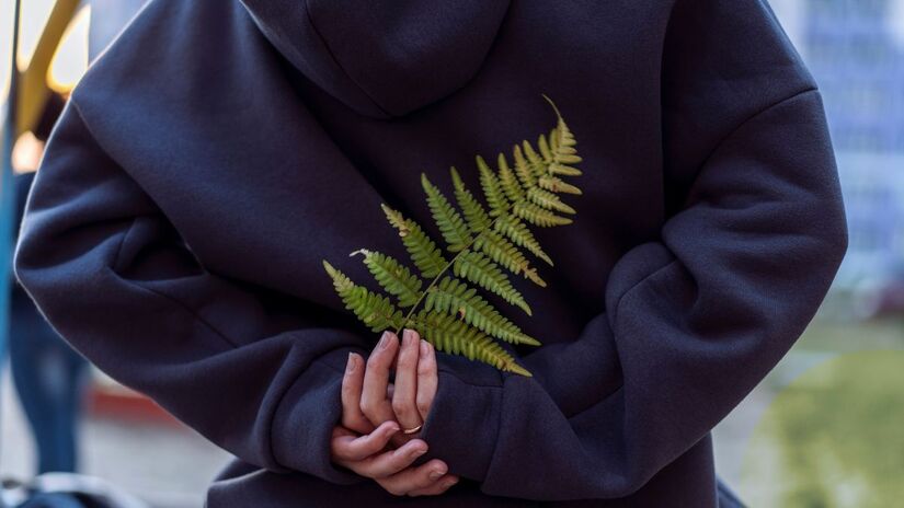 Braços cruzados é um sinal clássico de barreira. Embora nem sempre seja hostilidade, sugere que a pessoa está na defensiva/Unsplash