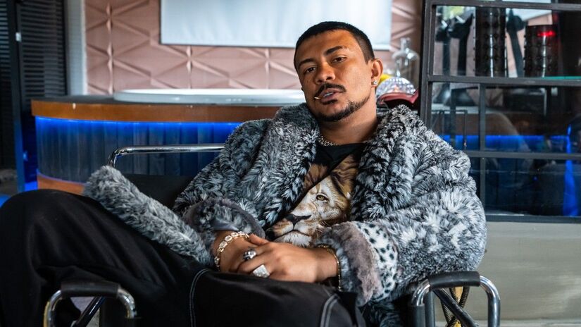 A figurinista Paula Carneiro explica que as roupas de Bagdá, frequentemente amplas e texturizadas, servem para que ele "ocupe um espaço" visualmente, reforçando seu posto e onipresença na trama/Reprodução/Redes Sociais