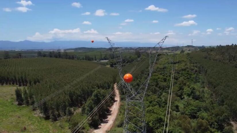 As esferas sinalizadoras são obrigatórias em rotas aéreas e perto de aeroportos. Elas têm cores vibrantes para garantir que os cabos sejam vistos a até 1 km de distância/Reprodução/YouTube