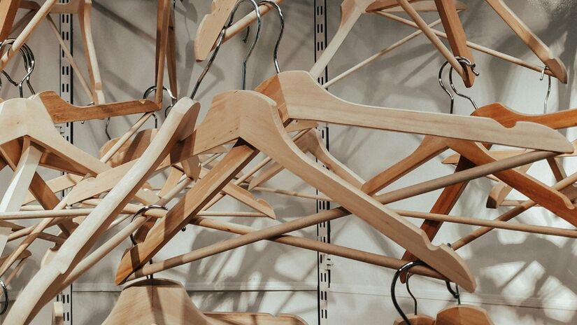 Ao contrário dos modelos de metal ou plástico, os cabides de madeira oferecem uma base durável e uma estética natural que se integra facilmente a diferentes estilos de decoração/Unsplash