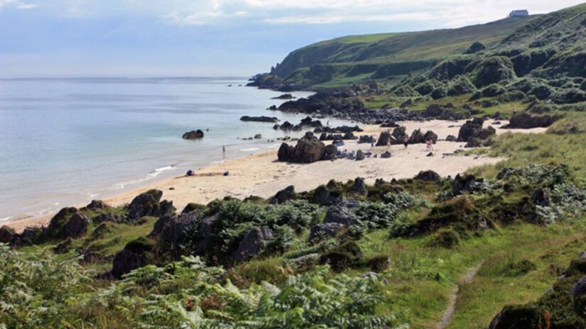 Praia de Traigh Bhan  Uma das mais charmosas da ilha, mistura falésias verdes e mar calmo, ideal para caminhadas e contemplação/ Peter Church/Wikimedia Commons