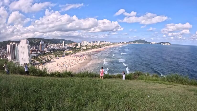 Praia da Enseada, no Guarujá, recebeu grande fluxo de turistas mesmo com cobranças elevadas nos quiosques durante a virada do ano/ Reprodução Youtube/Destino Praia