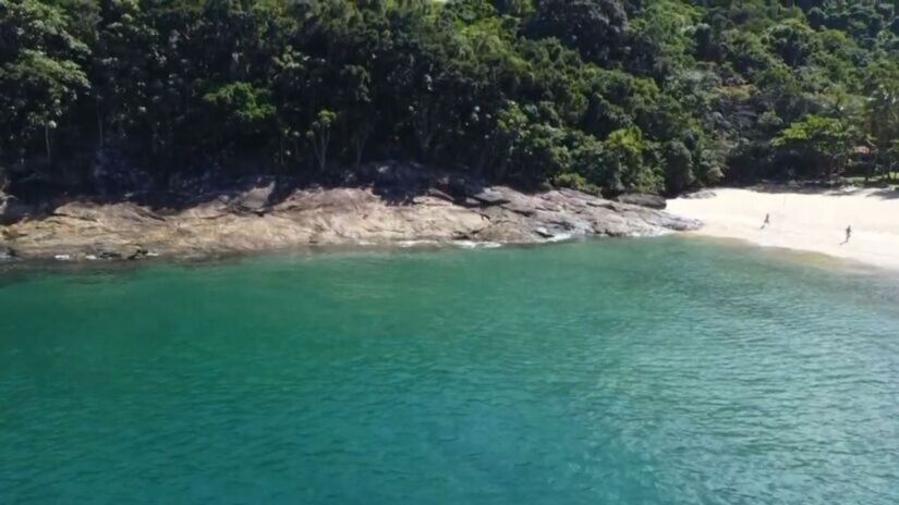 Para quem busca relaxar sem riscos, o canto esquerdo da praia oferece um rio de água doce raso, ideal para crianças e para quem quer apenas descansar (Reprodução/YouTube Rolê para Leigos)