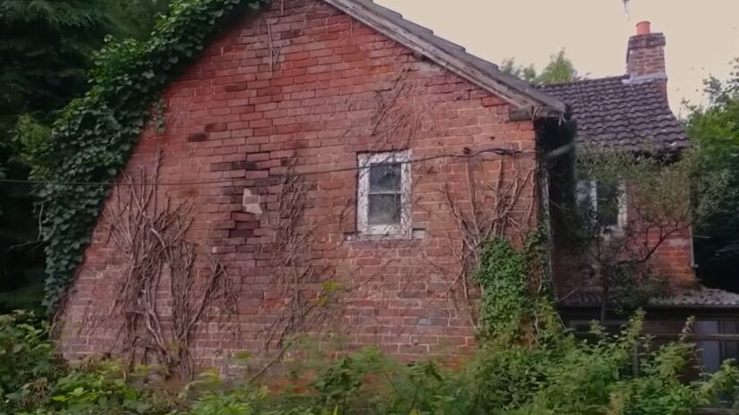 A fachada original estava completamente escondida pela vegetação e exigiu meses de limpeza pesada. Reprodução/Youtube