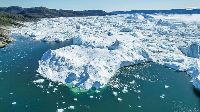 A maior ilha do mundo enfrenta um processo acelerado de derretimento de gelo, fenômeno que altera sua estrutura geológica e pode impactar o equilíbrio climático global. Wikimedia Commons/Giles Laurent