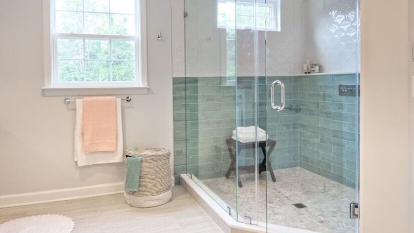 Enquanto a cortina cria uma barreira visual que divide o ambiente ao meio, o box de vidro transparente integra o espaço e permite que a luz circule livremente/Freepik