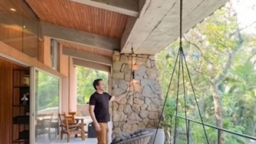 A casa tem cerca de 670 m² de área construída e segue um estilo modernista, com uso de madeira e pedra natural/Reprodução