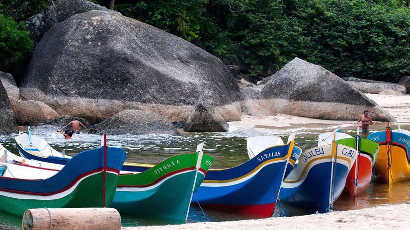Canoas e embarcações na chegada à Praia do Bonete. O trajeto pelo mar, que parte do extremo sul de Ilhabela, leva cerca de 40 minutos e oferece uma visão privilegiada de paredões rochosos e a chance de avistar golfinhos (João Lara Mesquita/commons wikimedia)