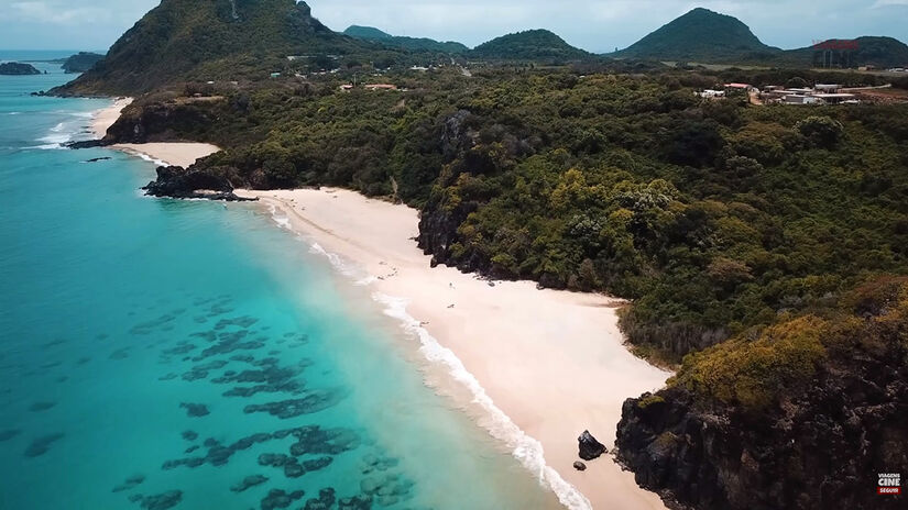 Entre abril e junho, as chuvas criam cachoeiras temporárias que despencam dos paredões direto na areia da praia / Foto: Reprodução/YouTube Viagens Cine