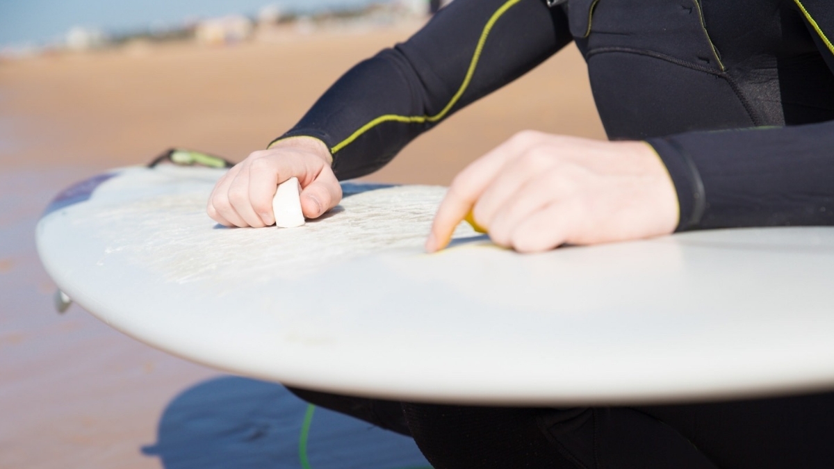 Surfista utilizando parafina na prancha 