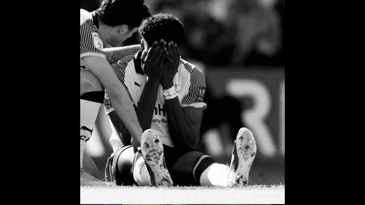 Patrick Agyemang com as mãos sob o rosto sentado no chão