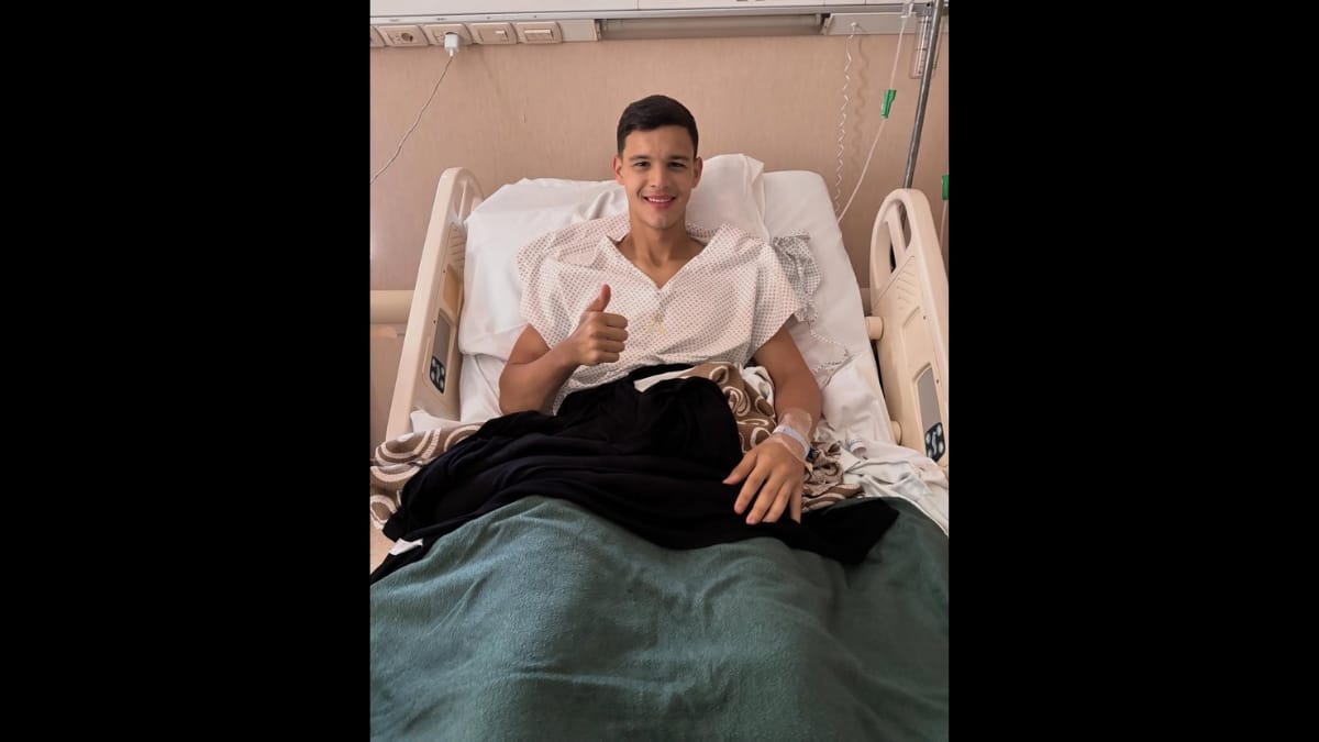 Valentín Carboni acenando pra foto deitado na maca