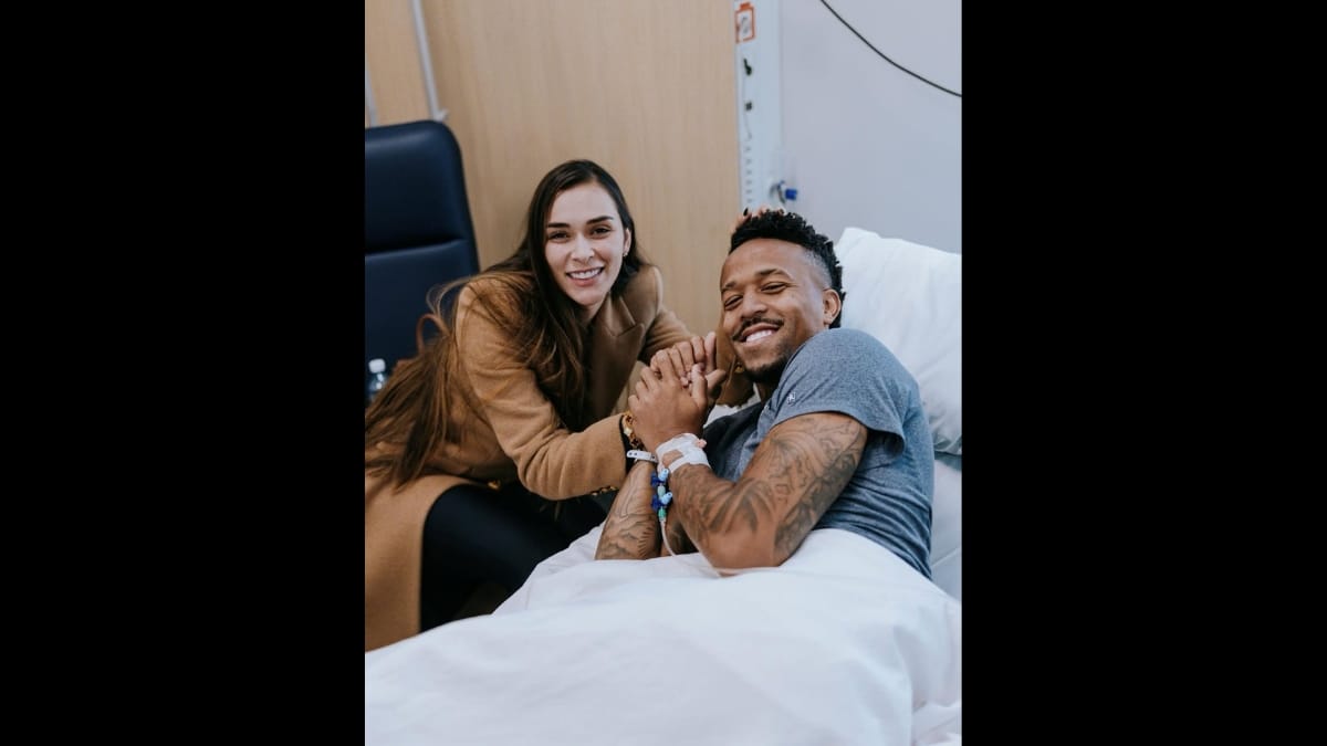 Militão segurando mão da esposa após cirurgia