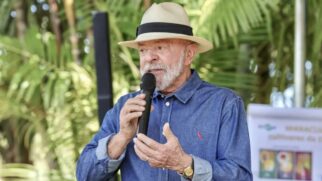 Lula falando com microfone. Na foto, o politíco aparece vestindo um chapéu