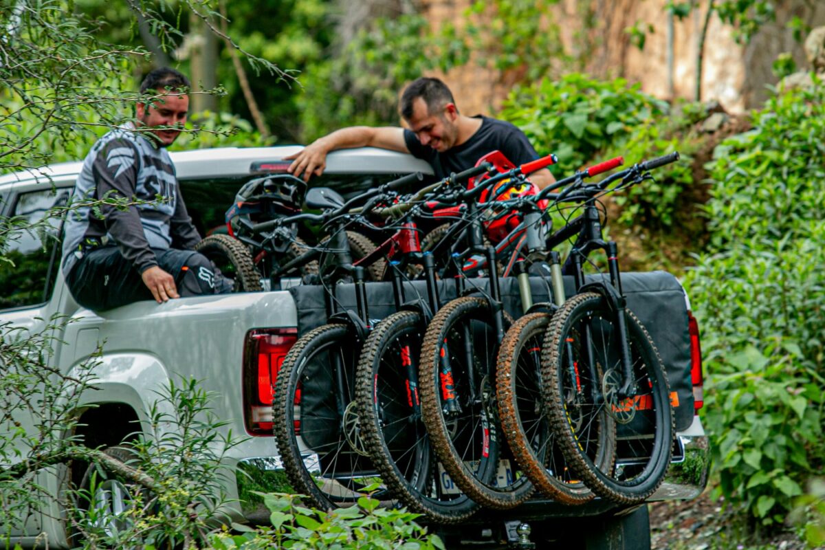 Dois homens armazenam bicicletas na traseira de uma picape