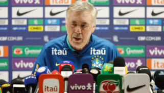 A imagem mostra Carlo Ancelotti em uma entrevista coletiva