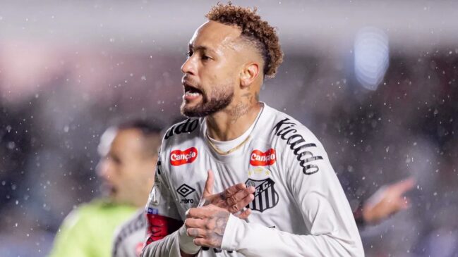 Jogador do Santos FC durante partida sob chuva, usando uniforme branco e faixa de capitão.
