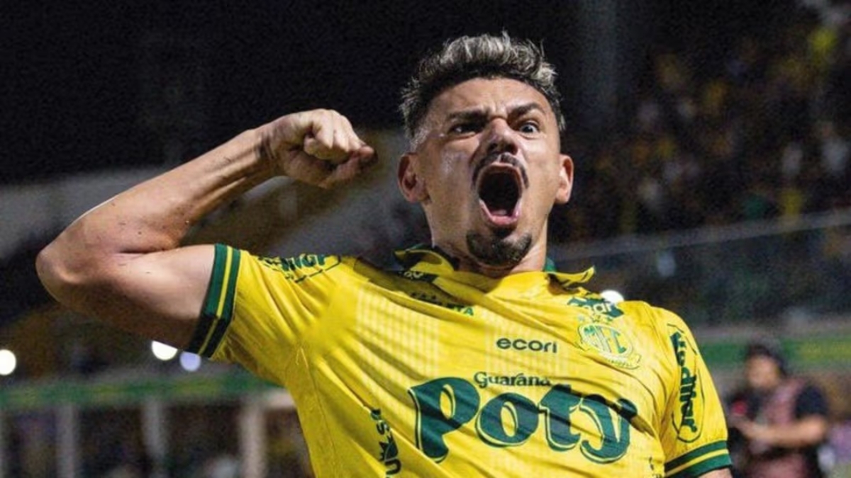 Jogador do Mirassol a celebrar intensamente, com o punho erguido e a gritar, vestindo a camisola amarela do clube.