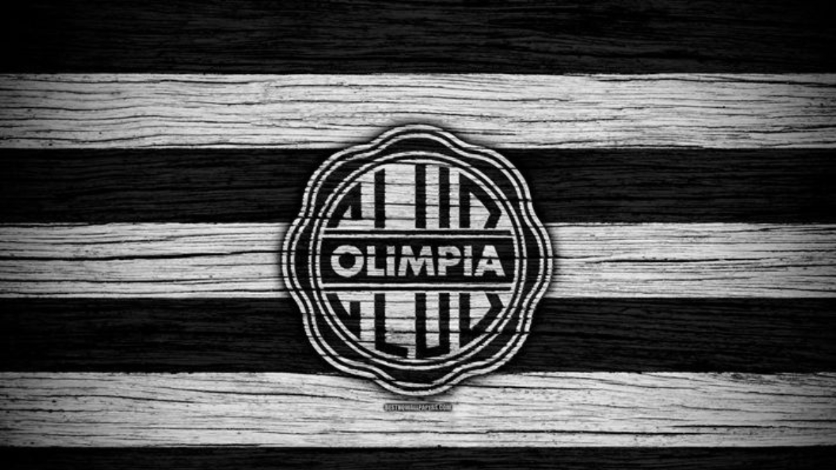 Escudo do Olimpia sobre fundo de listras pretas e brancas.