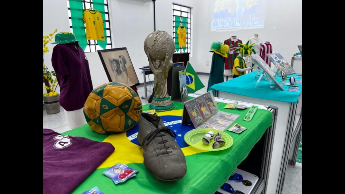 Chuteira de couro antiga, bola da Copa de 94 e réplica da Taça FIFA.