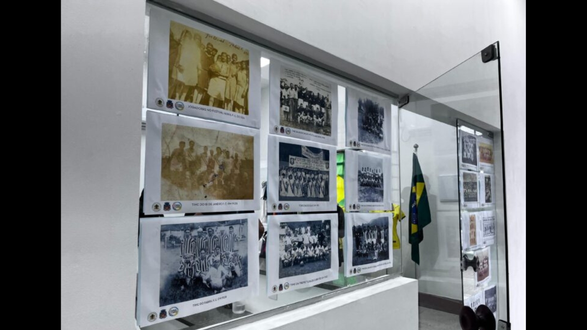 Fotos em preto e branco de antigos times de futebol no vidro da entrada.