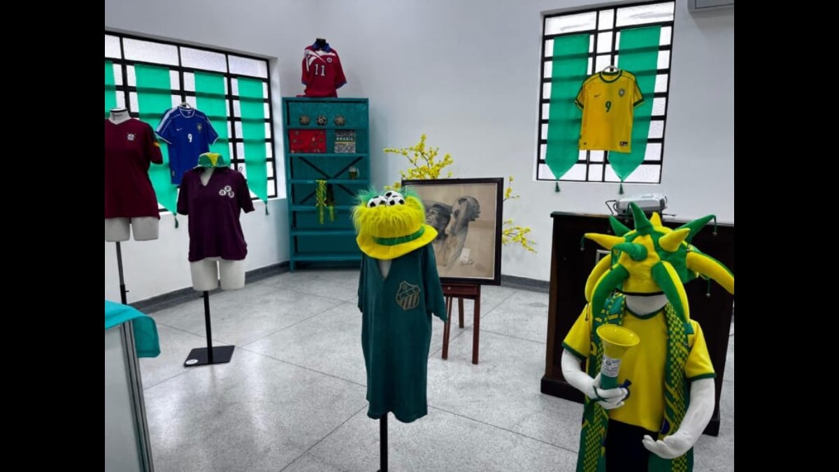 Salão da exposição com manequins vestindo uniformes esportivos antigos.