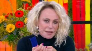 Apresentadora Ana Maria Braga com expressão séria e reflexiva, vestindo blusa preta, durante o programa Mais Você