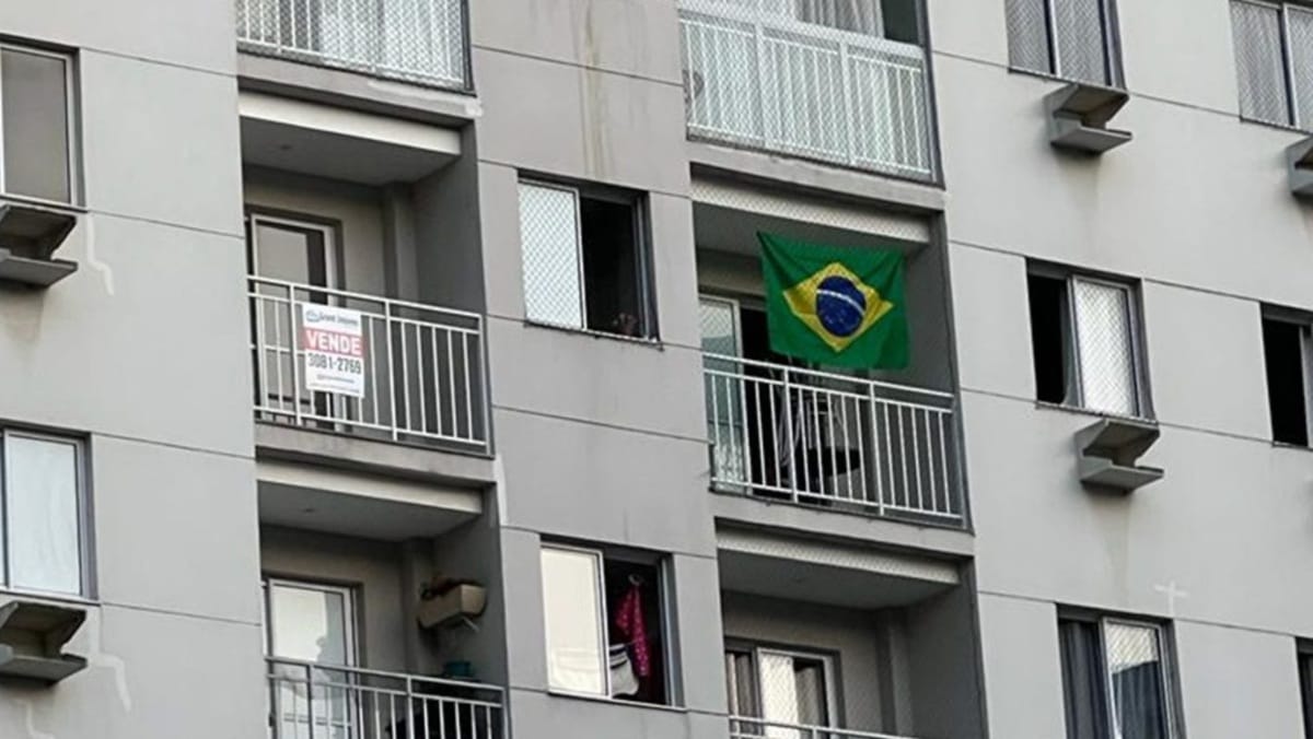 Bandeira do Brasil pendurada em janela de condomínio