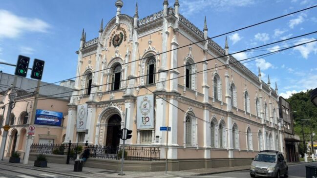 Prédio histórico do Centro Português, com fios de energia e carros trafegando na rua
