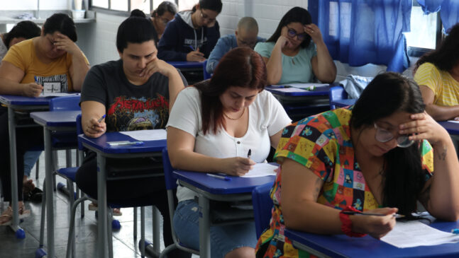 A imagem mostra uma sala durante a prova de concurso publico