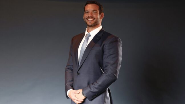 Fotografia oficial em plano médio do presidente da CBF Samir de Araújo Xaud de terno sorrindo em um estúdio