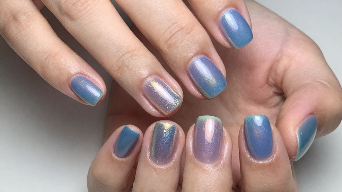 Mãos com unhas pintadas com esmalte holográfico (tridimensional)