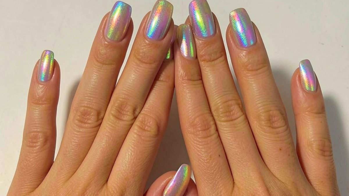 Mãos com unhas pintadas com esmalte holográfico (tridimensional)
