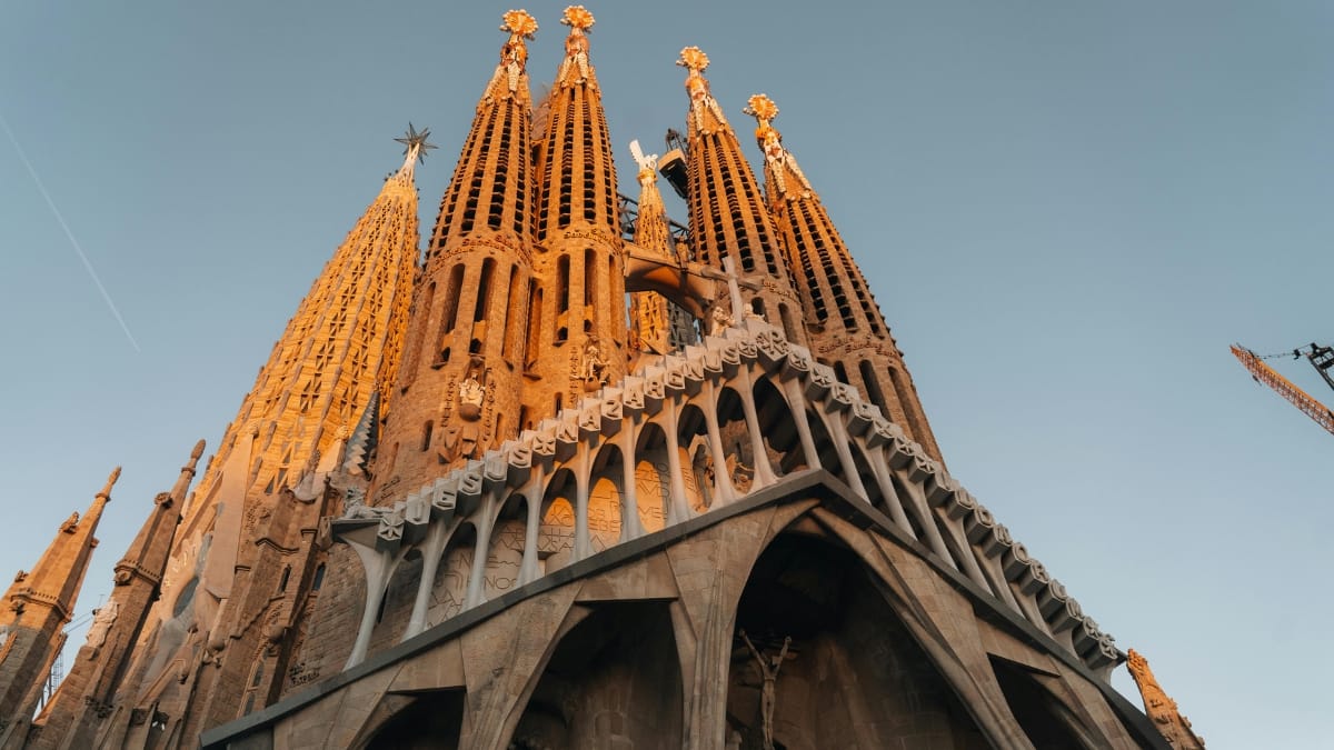 Torres da Basílica da Sagrada Família vistas de baixo, destacando a arquitetura detalhada da construção.