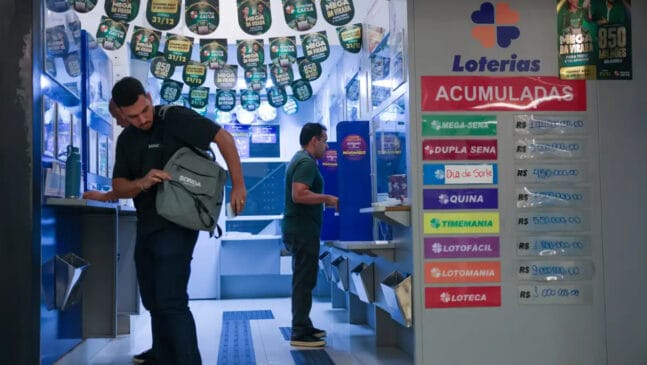 A imagem mostra pessoas fazendo seus jogos na loteria